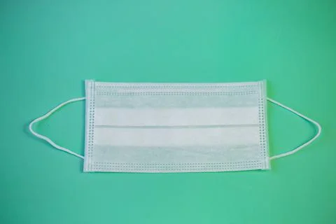 Medical protective face mask on a solid turquoise background Foto stock