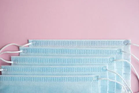 Medical protective masks on a pink background. Disposable 3-ply medical mask to Stock Photos