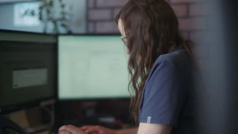 A medical receptionist typing on computer in the reception office Stock Footage 245109374