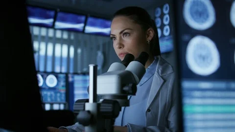 Medical Research Scientist Looking under the Microscope in the Laboratory. Stock Footage