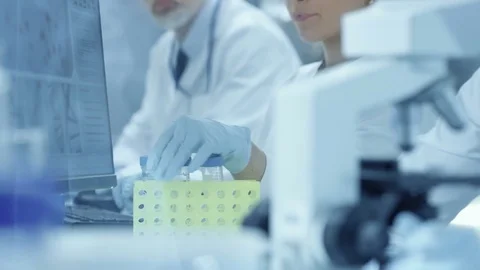 Medical Research Scientists Talks with Colleague and Looks at the Test Tube  Stock Footage