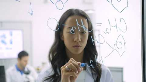 Medical research scientists writes scientific formula on a glass whiteboard. Stock Footage