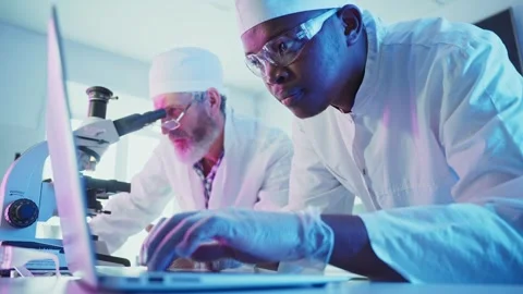 Medical research team analyzing data on laptop in laboratory 스톡 동영상 306587214