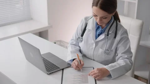 A medical science specialist, analyzing the data, creates a report with Video stock 263153402