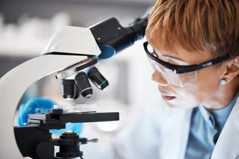 Medical science, woman and glasses at microscope in a laboratory for research Stock Photos