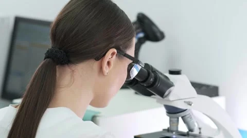 A medical scientist conducts experiments with a microscope Видео 269311186