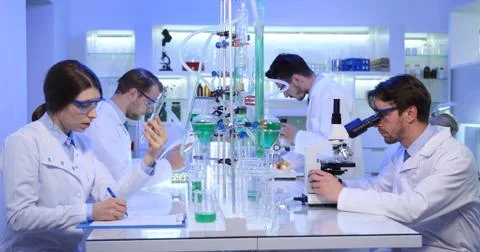 Medical Scientists Working on Microscope Team Talking Glassware Laboratory Room Stock Photos