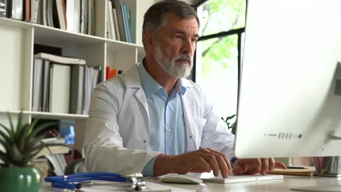 Medical specialist working with computer typing sitting at desk in clinic office Video stock 161317666