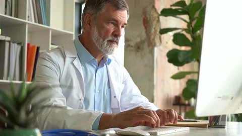Medical specialist working with computer typing sitting at desk in clinic office Stock Footage 161318897