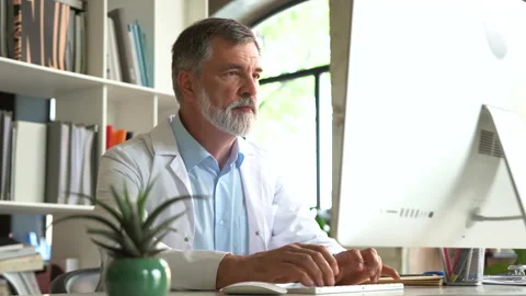 Medical specialist working with computer typing sitting at desk in clinic office Stock Footage 161324323