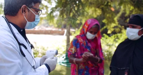 Medical staff doctors outdoors with a senior female in rural India Stock Footage
