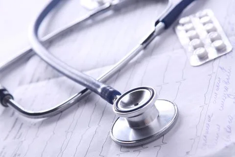Medical stethoscope on electrocardiogram on desk Stock Photos