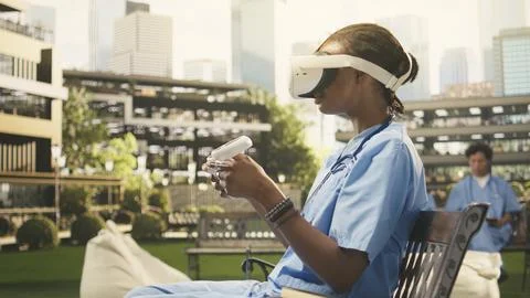 Medical student using VR controllers and headset on wooden bench Stock Photos