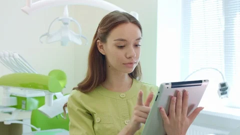 Medical student working on tablet pc in dental office. Woman doctor using tablet Vídeos de archivo 97215634