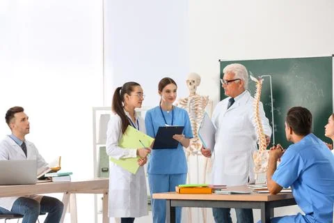 Medical students and professor studying human spine structure in classroom Stock Photos