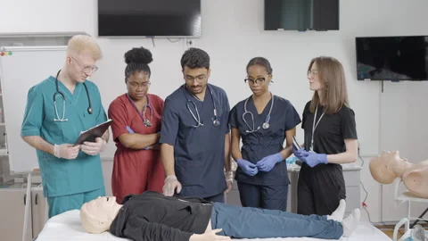 Medical students with instructor practicing first aid in clinic Stock Footage 278459049