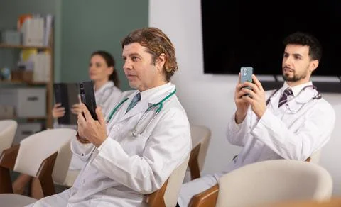 Medical students or doctors using mobile phones to scan QR-code during Stock Photos