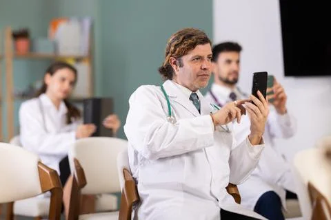 Medical students or doctors using mobile phones to scan QR-code during Stock Photos
