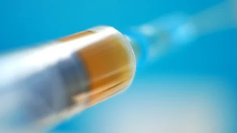 Medical syringe with needle in hand doctor on green or blue background Stock Footage