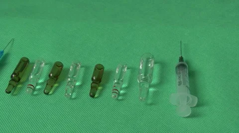 Medical syringes and vials on green background Video stock 59120878