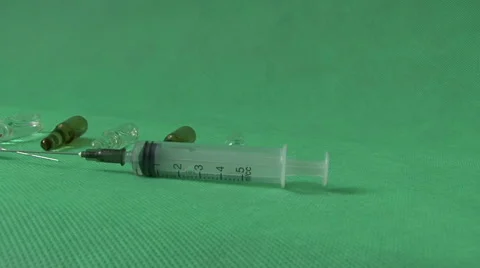 Medical syringes and vials on green background Video stock 59121155