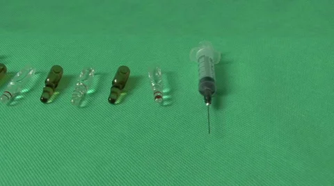 Medical syringes and vials on green background Video stock 59121183