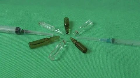 Medical syringes and vials on green background Stock Footage 59124860