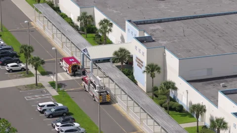 Medical team attends to emergency at school entrance. Aerial view Stock Footage 317648853
