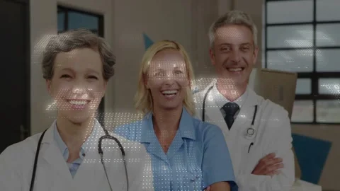 Medical team posing and smiling in clinic while dot overlay scrolling across Stock Footage 332281423