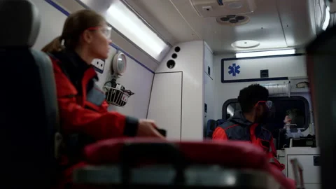 Medical team talking about work in emergency vehicle. Doctors driving on call Stock Footage 166890814