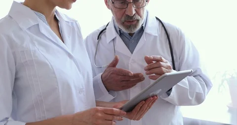Medical team two doctors using tablet, shake hands, closeup Stock Footage 126879827
