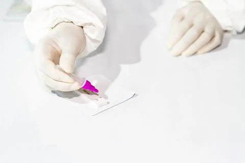 Medical technicians drop samples on antigen test kit to detect covid-19. Foto stock