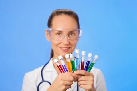 Medical test tubes with fluid sample closeup in doctor hand on blue backgroun Fotos Stock