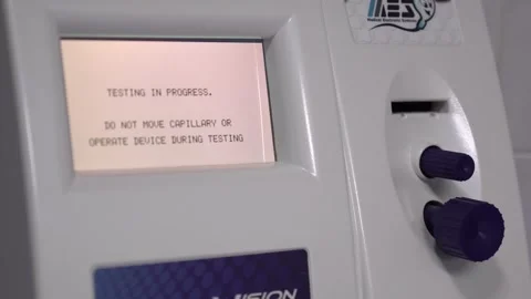 Medical testing device screen showing progress message and purple knobs in a 스톡 동영상 297237300