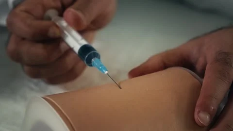 Medical Training Injection Practice on a Simulated Patient Skin Model Stock Footage 331110710
