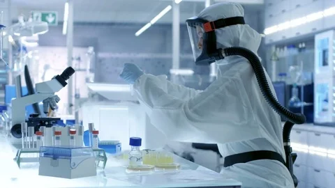 Medical Virology Research Scientist Works in a Hazmat Suit with Mask Stock Footage