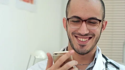 Medical worker checking his phone and laughing Video stock 72374727