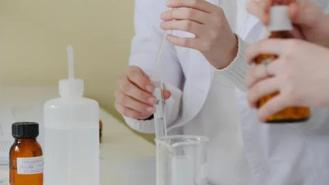 Medical worker with dropper testing fluids. Student used laboratory vessels in 库存照片