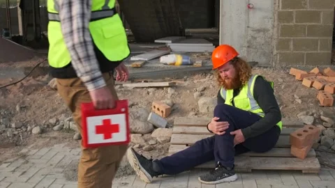 Medical worker with first aid kit comes up to assist to wounded worker Stock Footage 274480008