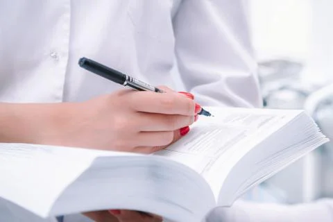 Medical worker with holding a large reference book Stock Photos