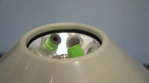 A medical worker inserts a test tube with a blood test into a special manifold.  Stock-Footage 148124733