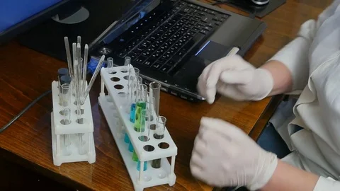 Medical worker makes testing with tubes and types on computer Stock Footage 84084806