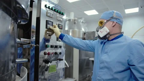 Medical worker in protective uniform operates the pharmaceutical machinery Stock Footage 200855326