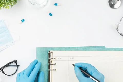 Medical worker at table write in notebook top view Stock-Fotos