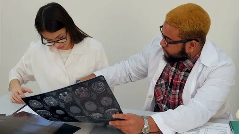 Medical workers discussing brain computed tomography x-ray image Stock Footage 71772829