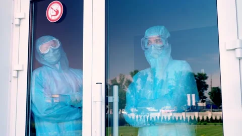 Medical workers in special protective suits. doctor and nurse looking tiredly Stock Footage 133293130