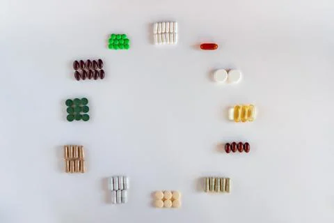 Medication with different types and colours as clock face on white background Stock Photos