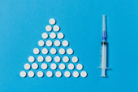 Medication white round tablets arranged in form triangle isolated on blue color Stock Photos