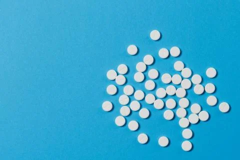 Medication white round tablets arranged abstract isolated on blue color Stock Photos
