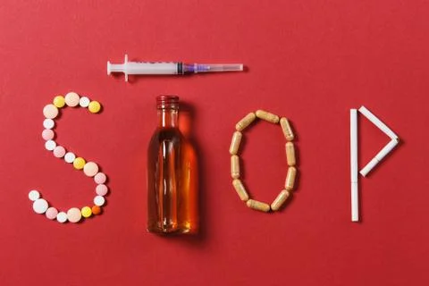 Medication white round tablets in word Stop. Creative composition with message Stock Photos
